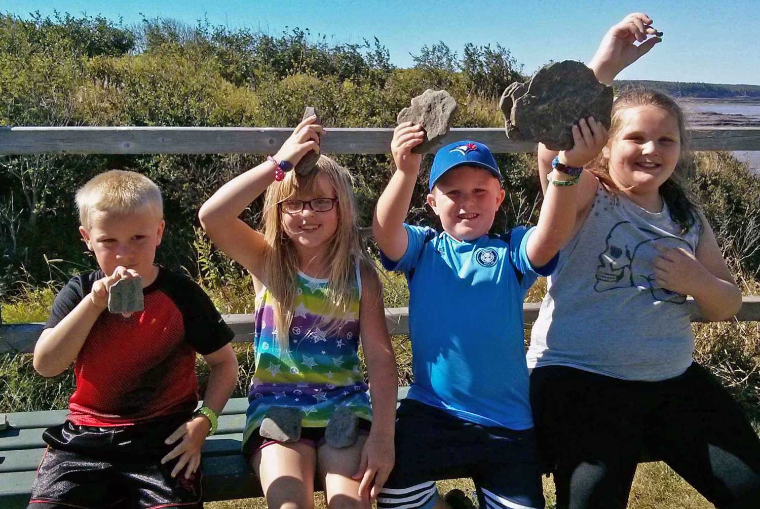 children holding up fossils